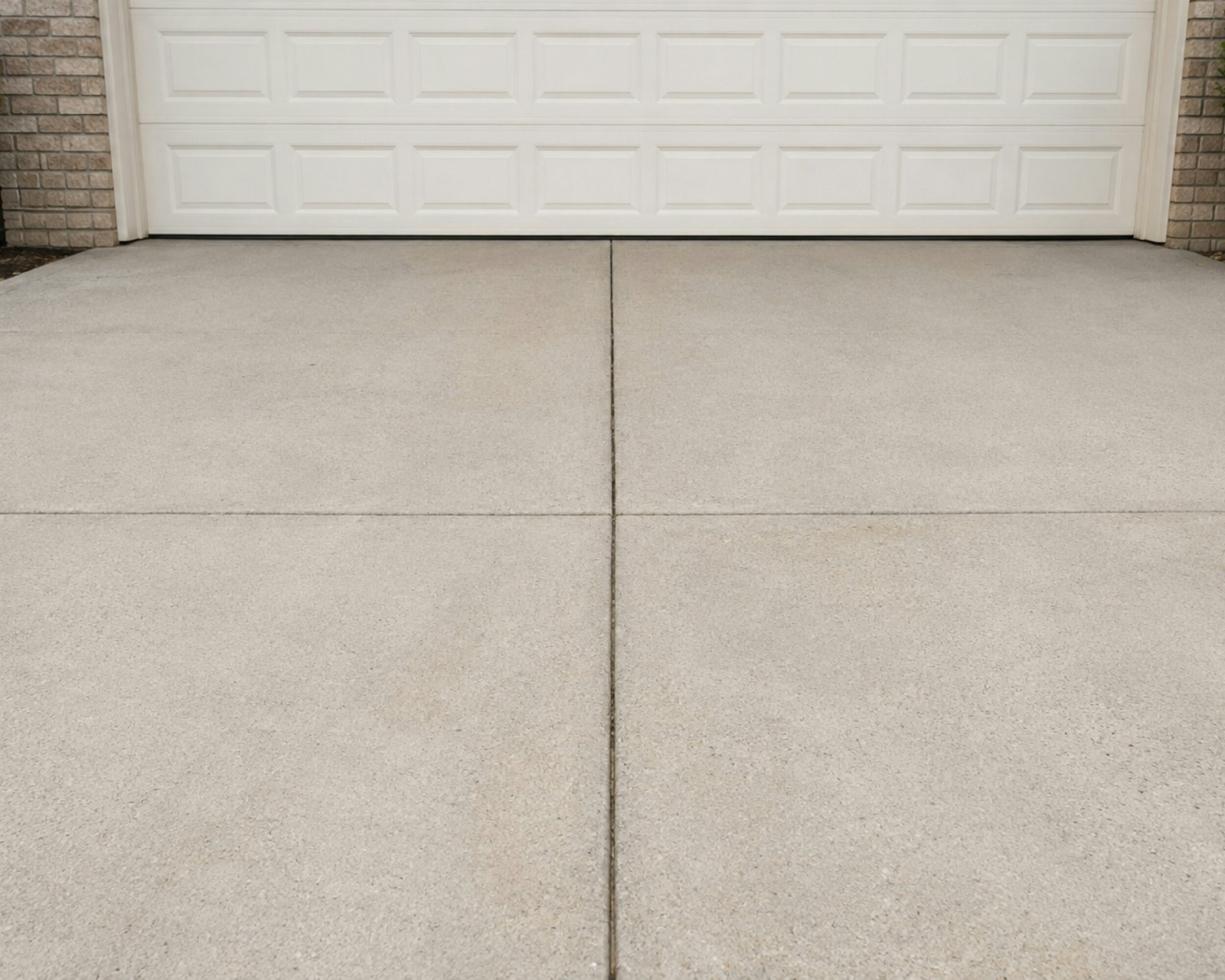 Concrete driveway leading up to a white garage